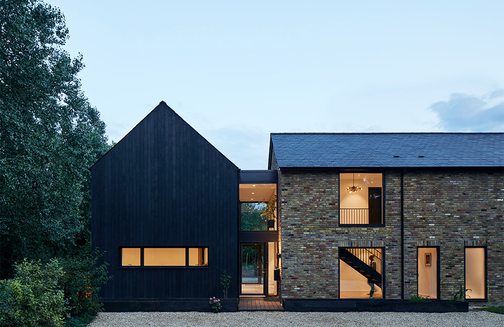 Front elevation of Napier Clarke's Samarkand house retrofit with its original brick section and the reclad black timber extension.